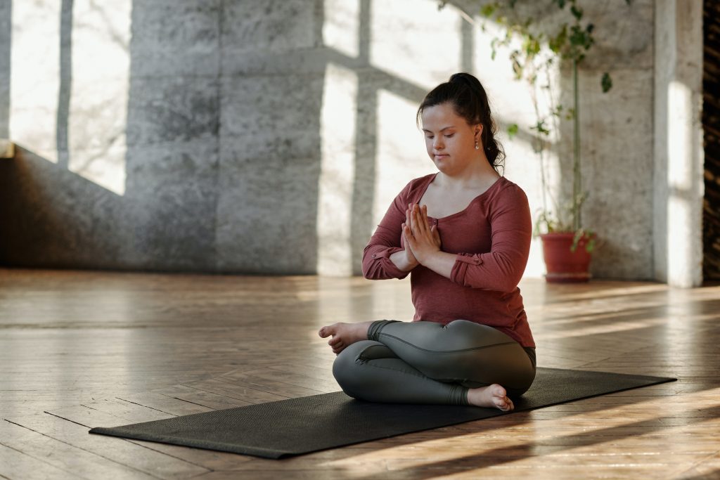 A woman meditates on a yoga mat.
